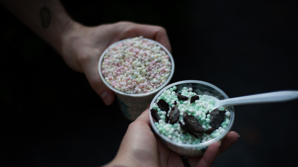 Hands holding cups of Dippin' Dots