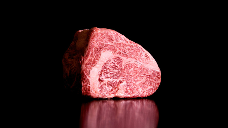 Red meat sitting on a black background 