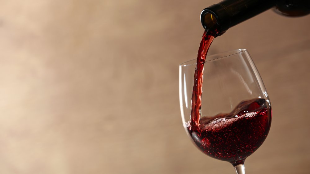 pouring red wine into a glass