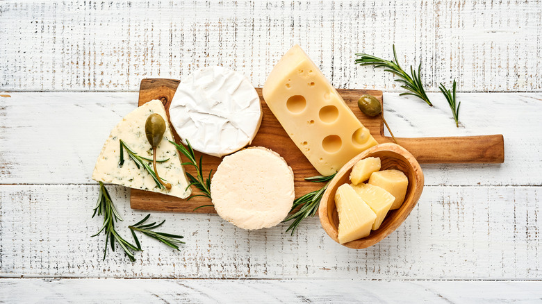 assorted cheeses on wooden board 
