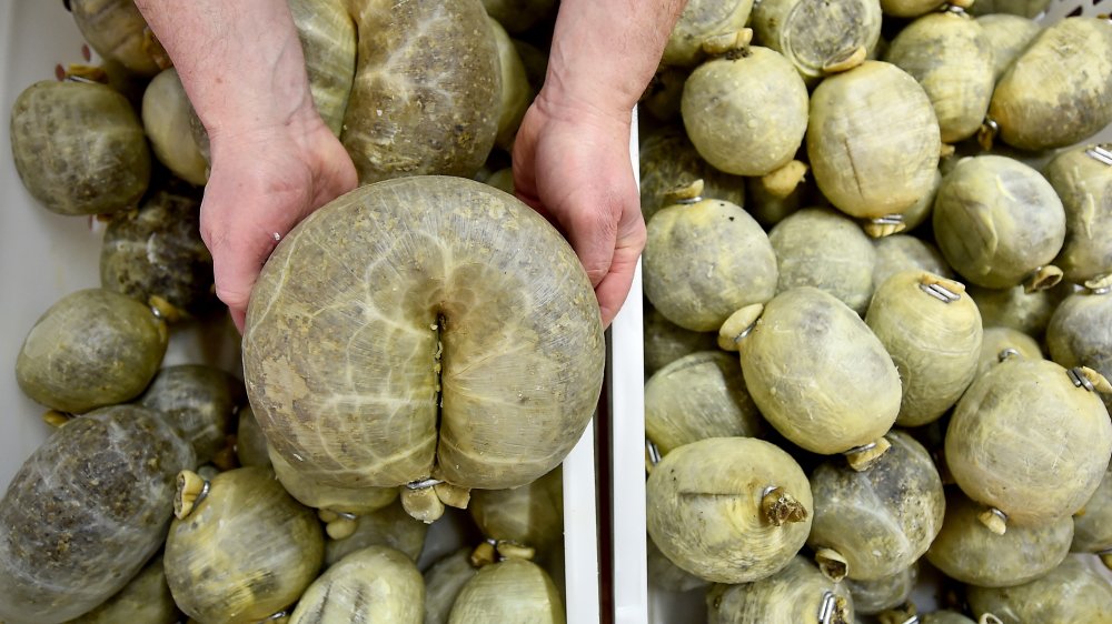 man's hands holding haggis for display