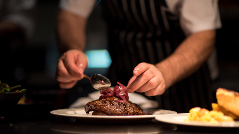 Chef adjusting meal on a plate