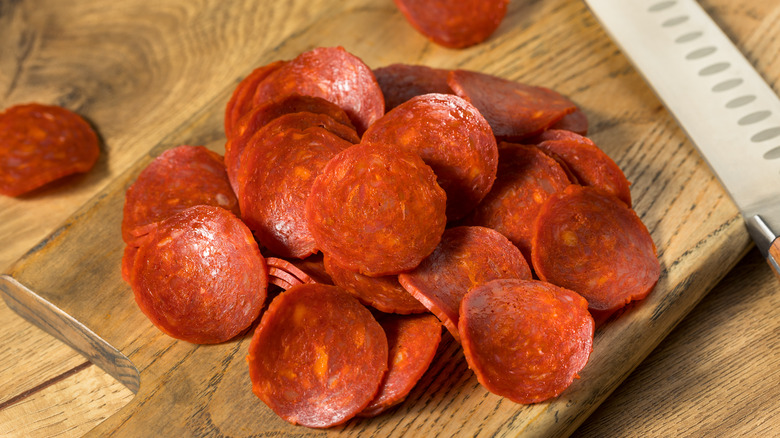 Pepperoni slices on wooden board