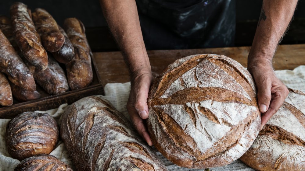 man holding loaf of bread 