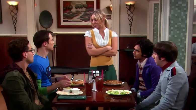 Penny serving Leonard, Sheldon, Raj, and Howard