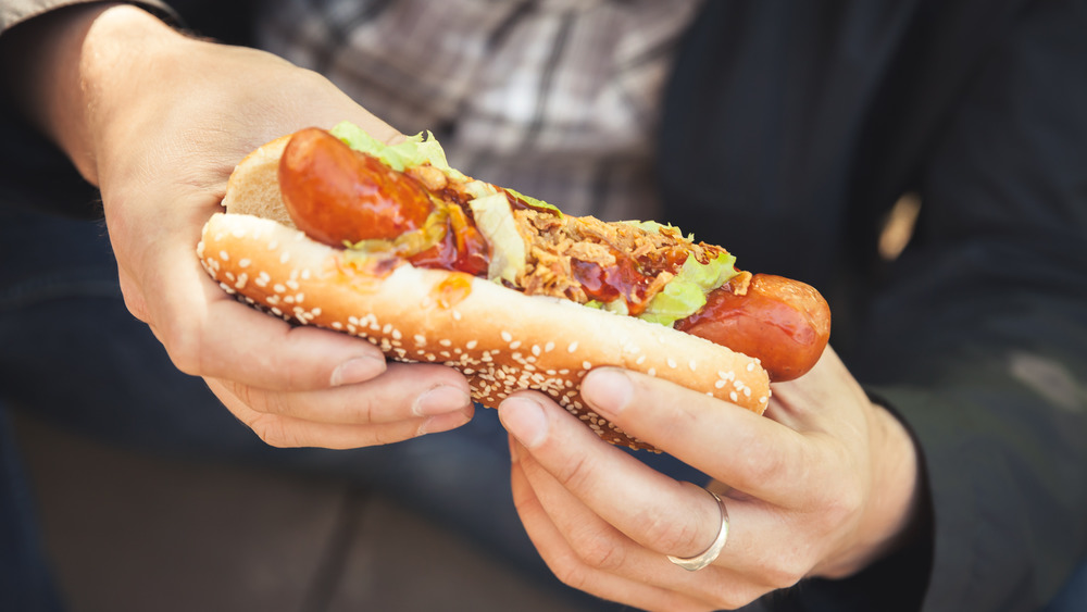 Hands holding hot dog