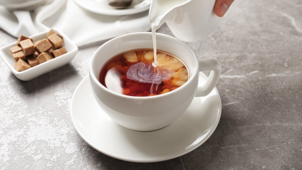 Milk being poured into a cup of tea