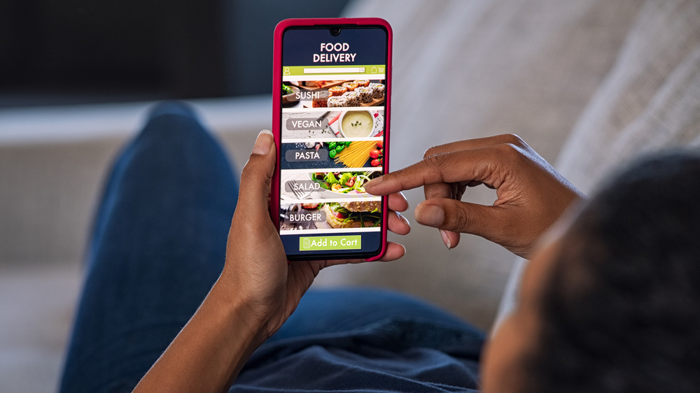 Person selecting food delivery on phone