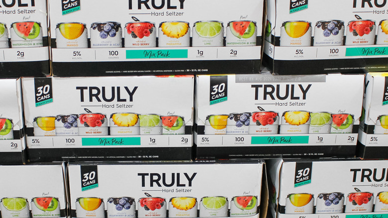 Cases of Truly hard seltzer sit on a store shelf. 