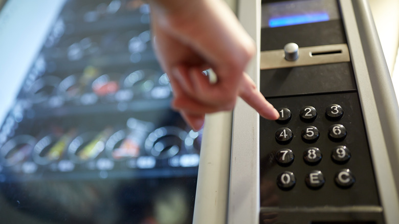 Finger pressing vending machine button