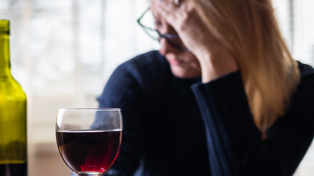 Woman with red wine and a headache