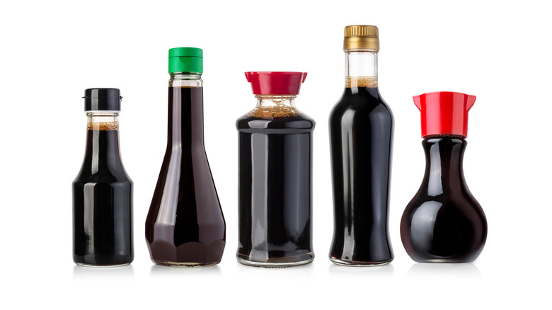 Bottles of soy sauce on white background