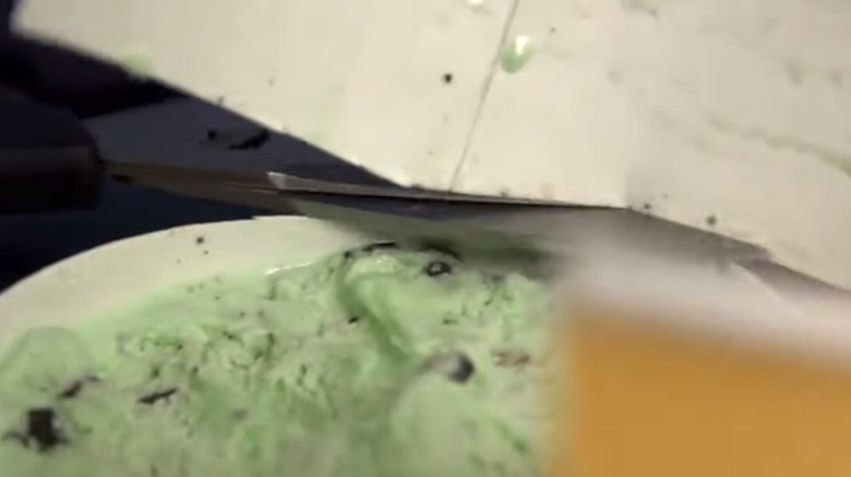 Scissors cutting ice cream container