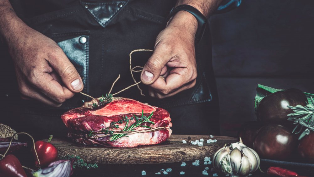 Tying up a cut of meat with butcher's twine