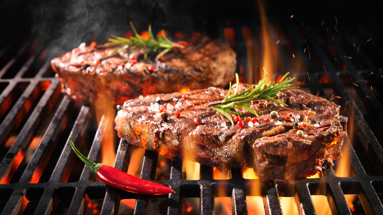 steaks on a hot grill over flame