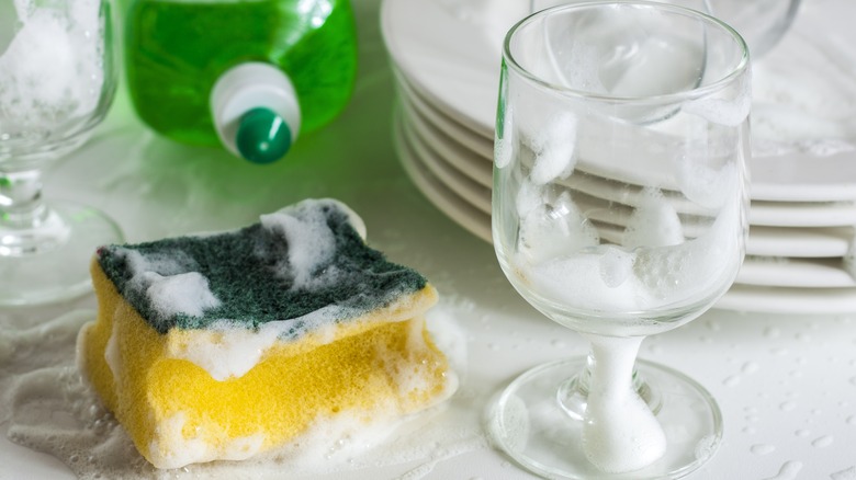 Glass with soap suds and sponge
