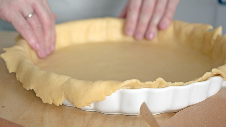 https://www.mashed.com/img/gallery/the-real-reason-your-pie-crust-keeps-burning/dough-overhang-fat-and-sugar-can-all-contribute-to-burning-1640847963.jpg