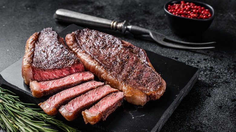 well-seared steak on black cutting board