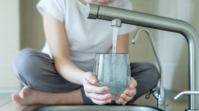 Person fills glass with tap water