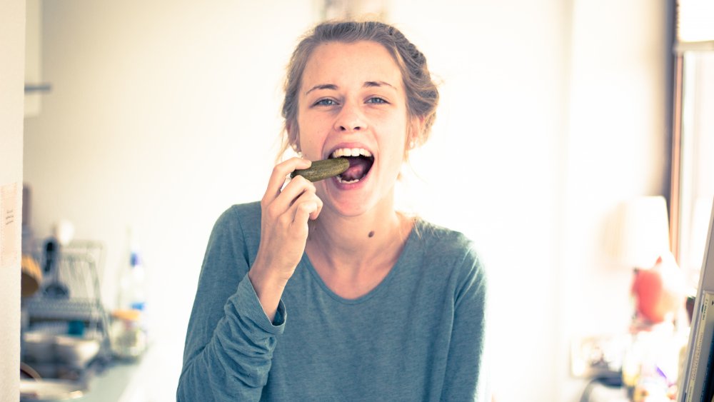 Woman eating a pickle