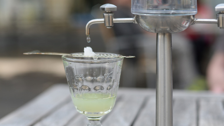 Glass of absinthe with sugar cube and fountain