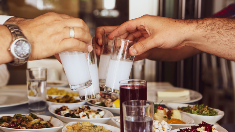 Arms of men toasting in a Turkish restaurant enjoying a meal