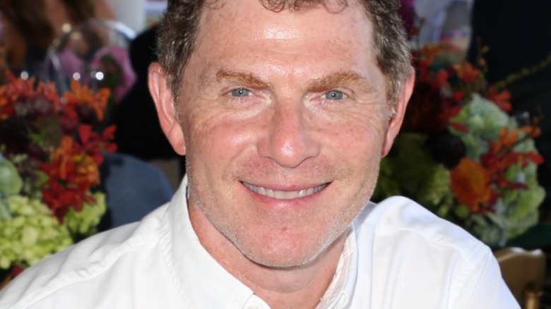 Bobby Flay smiles in chef uniform