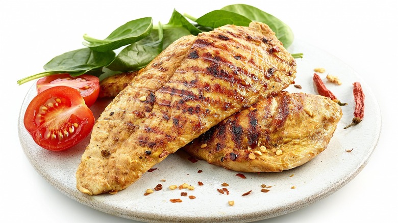 Grilled chicken breasts on a white plate 