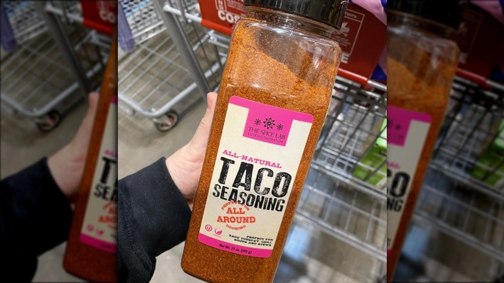 Hand holding bottle of taco seasoning