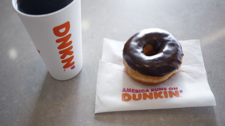 Paper cup of Dunkin' coffee and sprinkled donut