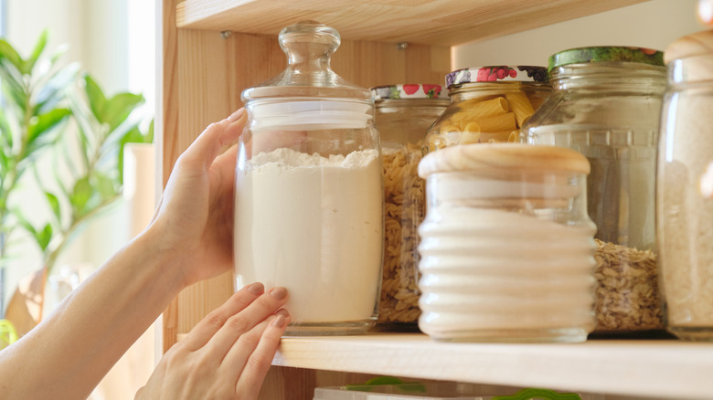 Person reaching for jar of flour