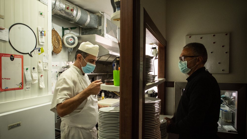 Restaurant employees interact through window