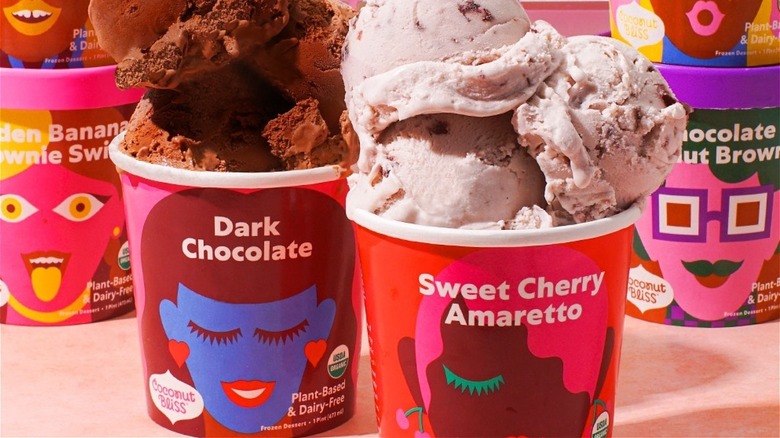 Pints of Coconut Bliss dark chocolate and sweet cherry amaretto flavors with scoops piled on top 