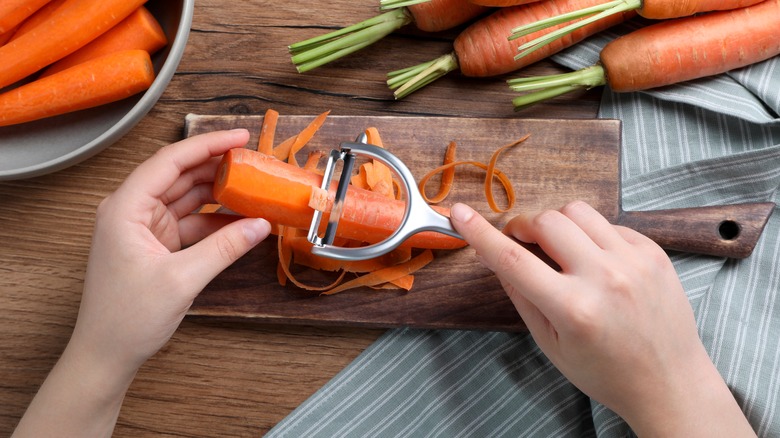 Using vegetable peeler on carrot