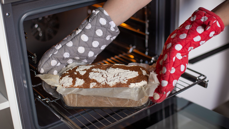 pulling bread out of oven