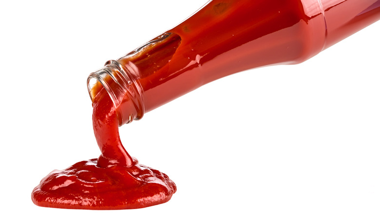 Ketchup being poured from glass bottle