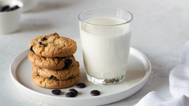 Cookies on plate with cup of milk 