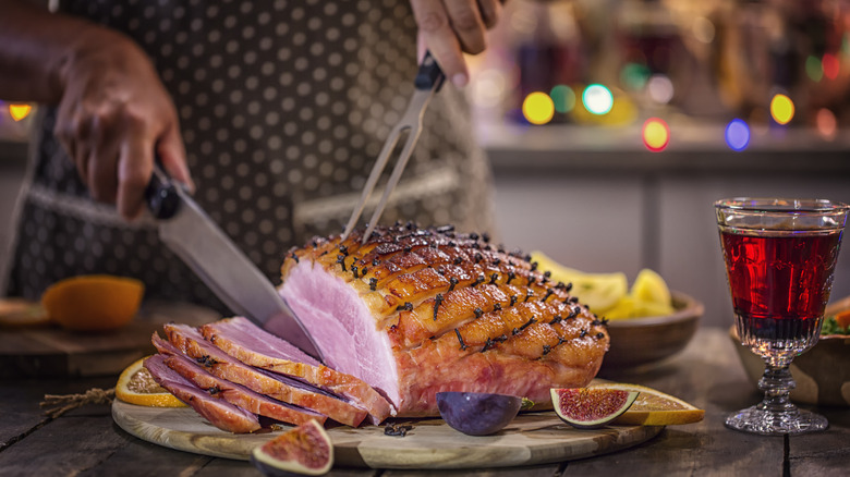 Slicing clove-studded ham 