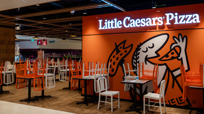 Inside a Little Caesars restaurant with chairs on tables