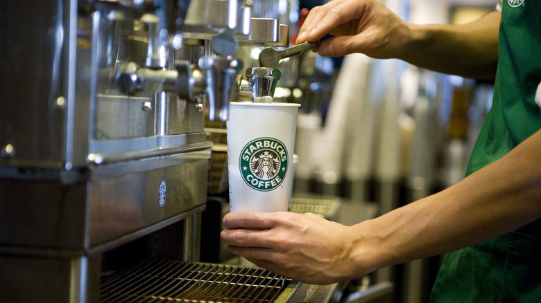 starbucks barista filling coffee cup