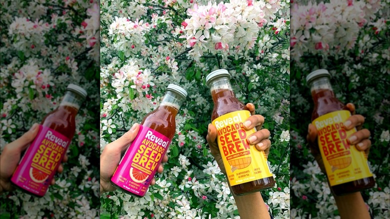 People holding Reveal drinks on flower background