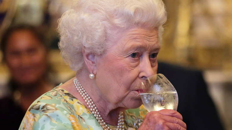 Queen Elizabeth II sipping from a glass