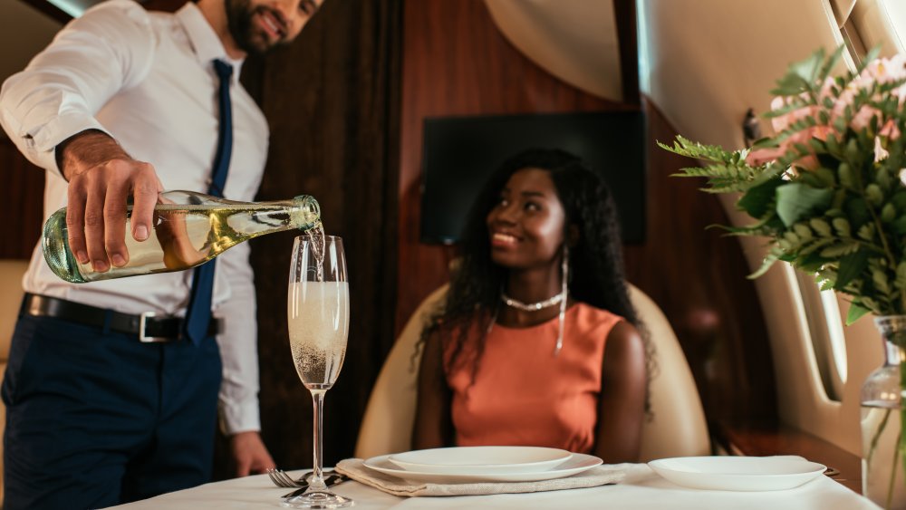 pouring champagne flight attendant private plane