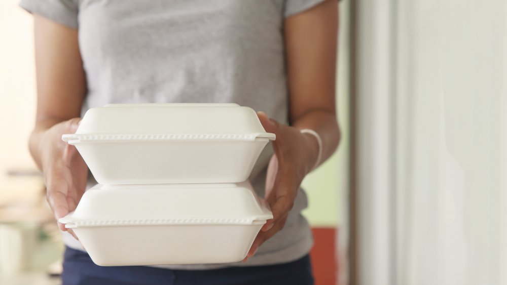 woman holding two take out containers