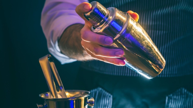 Barista using cocktail shaker to prepare a drink 