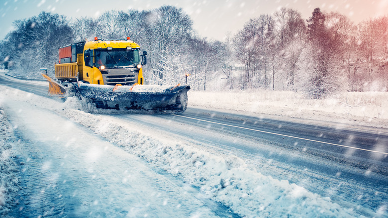 A plow attempts to clear snow as it continues to fall 