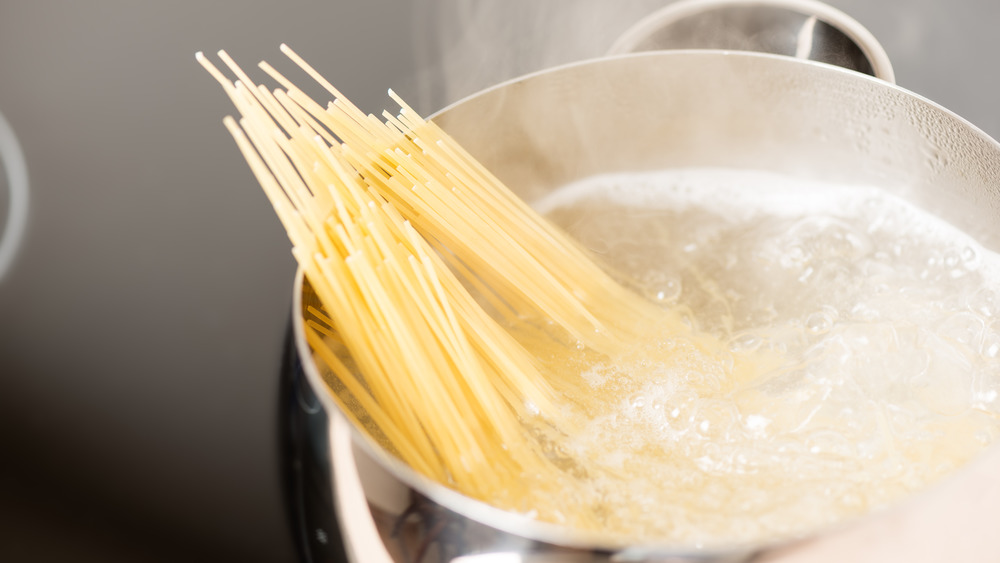 spaghetti cooking in boiling pot of water