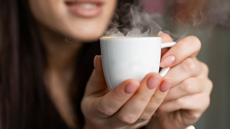 Woman holding mug of hot tea