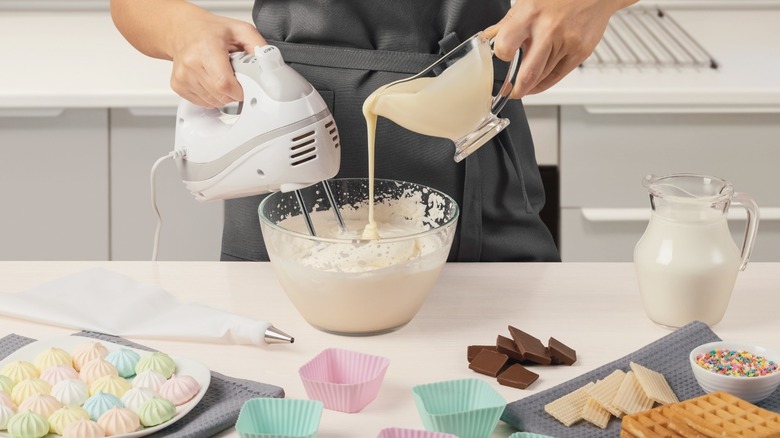 red stand mixer on a kitchen counter next to eggs