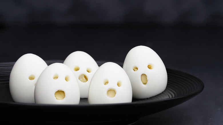 A plate of horrified-looking eggs with scared faces cut out